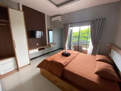 a bedroom with a large bed with a large window at Semilang House in Ngurah Rai International Airport