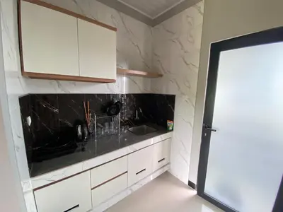 a kitchen with white cabinets and a sink at Semilang House in Ngurah Rai International Airport