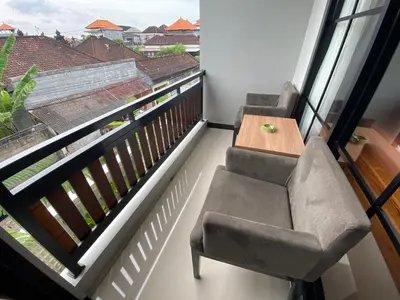 a balcony with two chairs and a wooden table at Semilang House in Ngurah Rai International Airport