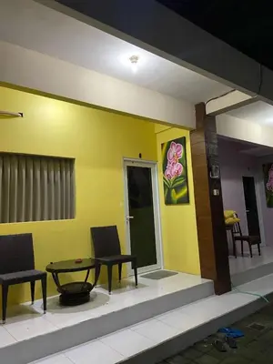 a room with a table and chairs and a yellow wall at Cozy room Kuta - 1 minutes to the beach by Micky Studio in Legian
