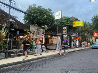 a group of people walking down a street at Cozy room Kuta - 1 minutes to the beach by Micky Studio in Legian