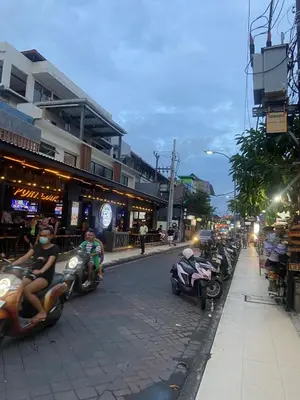 a group of people riding motorcycles down a city street at Cozy room Kuta - 1 minutes to the beach by Micky Studio in Legian
