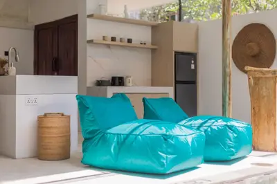 a living room with blue pillows on a table at Spring Villa Nusa Dua in Nusa Dua