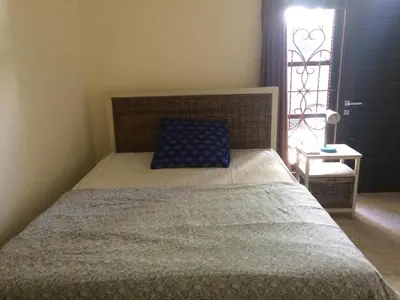a bedroom with a bed with a blue pillow and a window at Simple apartment 3 in Seminyak