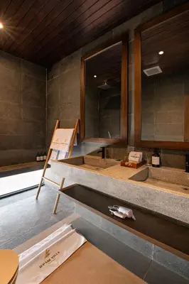a bathroom with a large mirror and a sink at D'Padi Villa Canggu in Canggu