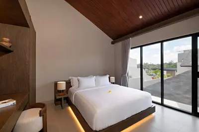 a bedroom with a white bed and a large window at D'Padi Villa Canggu in Canggu