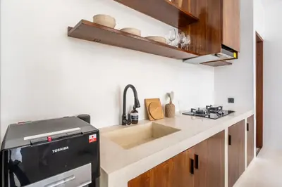 a small kitchen with a sink and a stove at Casa Nalani in Kerobokan