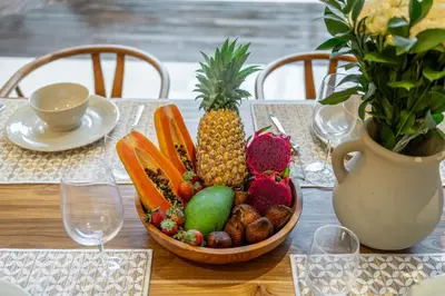a basket of fruit on a table with a vase at Sunterra 3- Luxurious 3BR Villa in Canggu with Pool in Kerobokan