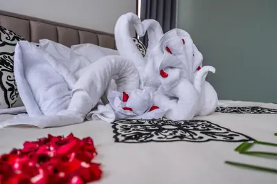 two stuffed animals sitting on a bed with roses at Villa Bima by JB Villas in Seminyak