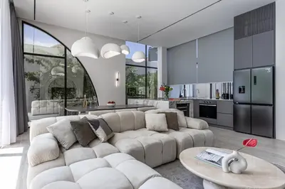 a living room with a white couch and a kitchen at Brand New Luxury 5 Stars Designer Villa by Amare Villas in Kerobokan