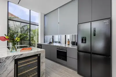 a kitchen with stainless steel appliances and a fireplace at Brand New Luxury 5 Stars Designer Villa by Amare Villas in Kerobokan
