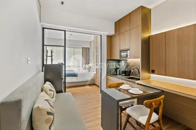 a kitchen and living room with a couch and a table at Calira by Kozystay - Nusa Dua in Nusa Dua