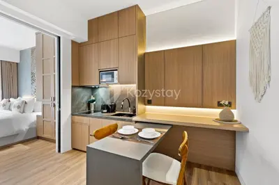a kitchen in a hotel room with a bed at Calira by Kozystay - Nusa Dua in Nusa Dua