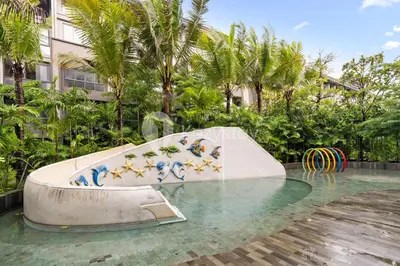 a slide in the middle of a swimming pool at Calira by Kozystay - Nusa Dua in Nusa Dua
