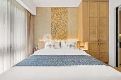 a bedroom with a large white bed in a room at Calira by Kozystay - Nusa Dua in Nusa Dua