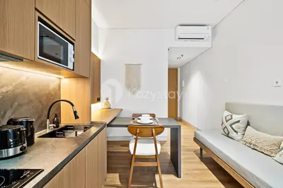 a small kitchen with a table and a couch at Calira by Kozystay - Nusa Dua in Nusa Dua