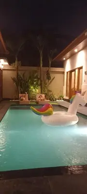 a pool with a swan and two inflatable boats at Ben & B villa in Kerobokan