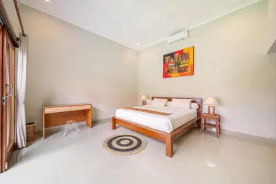 a bedroom with a bed and a night stand and a table at Ben & B villa in Kerobokan