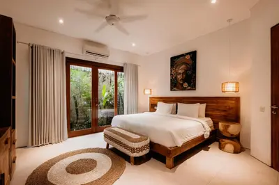 a bedroom with a bed and a large window at Villa Pacha Seminyak in Seminyak