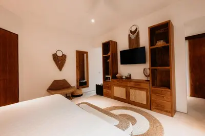 a bedroom with a bed and a tv on the wall at Villa Pacha Seminyak in Seminyak
