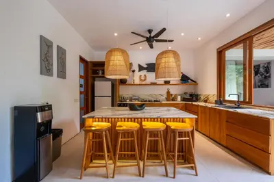 a kitchen with a wooden table and stools at Villa Pacha Seminyak in Seminyak