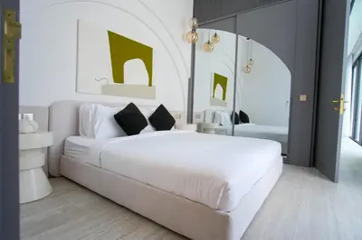 a white bedroom with a large white bed with two pillows at Brand New Luxury5 Stars Designer By Villa Amare Villa 3 in Kerobokan