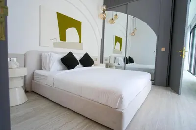 a bedroom with a large white bed and a mirror at Brand New Luxury5 Stars Designer By Villa-Amare Villa 1 in Kerobokan