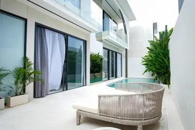 a balcony with a rattan chair and a table and some plants at Brand New Luxury5 Stars Designer By Villa-Amare Villa 1 in Kerobokan