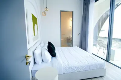 a bedroom with a bed with white sheets and pillows at Brand New Luxury5 Stars Designer By Villa-Amare Villa 1 in Kerobokan
