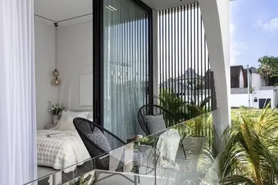 a balcony with two chairs and a bed on it at Brand New Luxury5 Stars Designer By Villa-Amare Villa 5 in Kerobokan