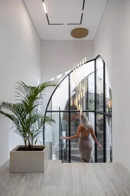 a woman walking into a room with a potted plant at Brand New Luxury5 Stars Designer By Villa-Amare Villa 5 in Kerobokan