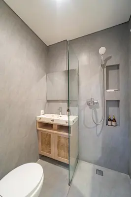 a bathroom with a toilet and a sink and a shower at The Hita Uluwatu in Jimbaran