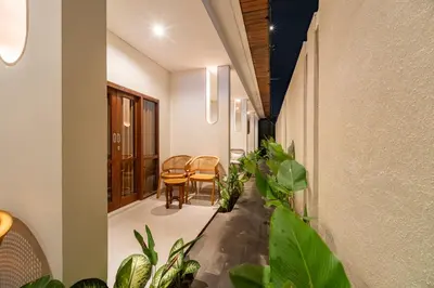a hallway with plants and a table and chairs at The Hita Uluwatu in Jimbaran