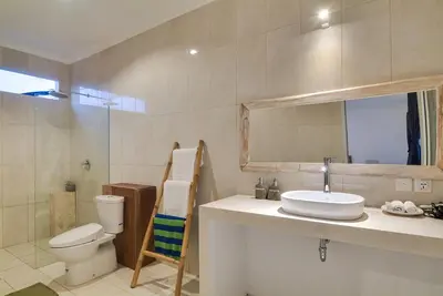 a bathroom with a sink and a toilet and a mirror at 3BR Villa4 Oberoi Seminyak,18m walk to the beach in Seminyak