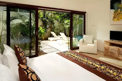 a bedroom with a large white bed and a patio at 2BR Villa Central Seminyak,50 m walk to the beach in Seminyak