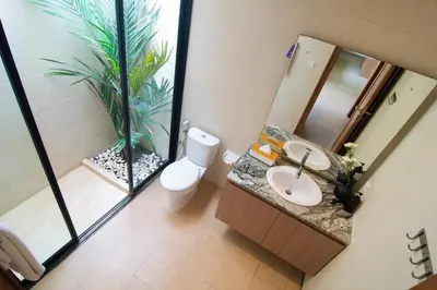 a bathroom with a toilet and a sink and a plant at LaBumbak 01 - 2BR Villa Escape in Umalas with Private Pool in Canggu