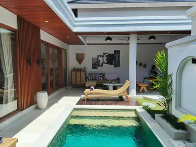 a swimming pool in the middle of a house at Rumah Kodel4 by iBali Management in Seminyak