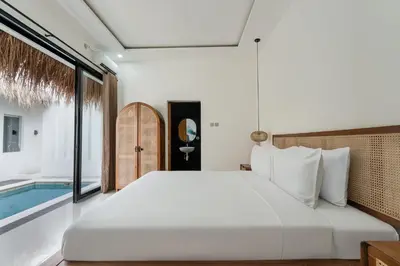 a bedroom with a large bed and a swimming pool at Queen Villa D1 by Betterplace in Seminyak