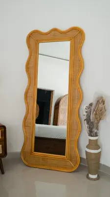 a mirror with a wooden frame on a wall at Queen Villa D1 by Betterplace in Seminyak