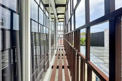a corridor of a building with glass windows at Garden Leaf Villa - 2 Bedroom Pool Villa with Minimum Stay 2 Nights in Nusa Dua
