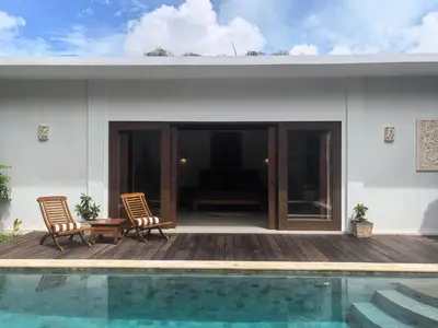 a house with two chairs and a swimming pool at Villa Veyla Seminyak 10 mins walk to beach in Seminyak