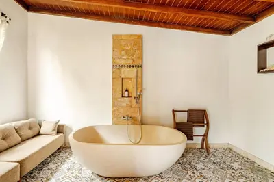 a large white tub in a living room with a couch at Villa Veyla Seminyak 10 mins walk to beach in Seminyak