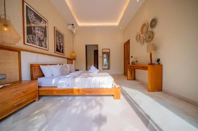 a bedroom with a bed and a dresser in it at Luxury Balinese Oasis with private pool - 2 BR in Kerobokan