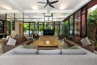 a living room with a couch and a table at Walk, Best of Berawa, 5bd villa, 2min from Finns in Canggu