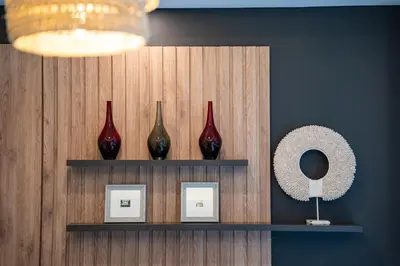 a shelf with three red vases and a mirror at Jimbaran Breeze Villa By Island Escape in Jimbaran