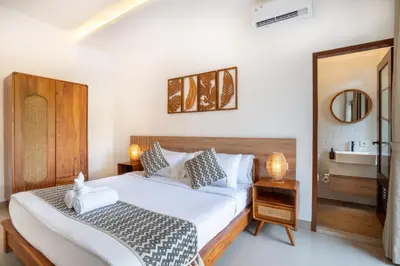 a bedroom with a large white bed and a sink at Jimbaran Breeze Villa By Island Escape in Jimbaran