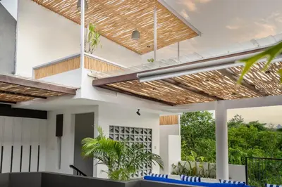 a modern house with a wooden ceiling at Jimbaran Breeze Villa By Island Escape in Jimbaran