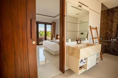 a bathroom with a sink and a bed and a mirror at NEW! 3BR HnRR Villa Near Seminyak in Kerobokan