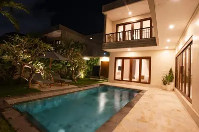 a swimming pool in the backyard of a house at night at NEW! 3BR HnRR Villa Near Seminyak in Kerobokan