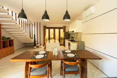 a kitchen and dining room with a wooden table and chairs at NEW! 3BR HnRR Villa Near Seminyak in Kerobokan